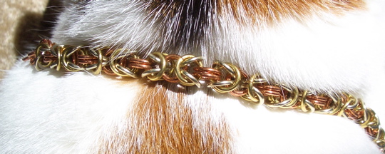 brass, silver, and copper chain around a cat's neck