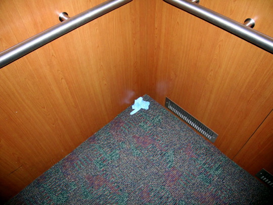 blue nitrile glove on the floor of an elevator. eww.